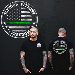 Man wearing a black t-shirt featuring a green line American flag design symbolizing the thin green line.