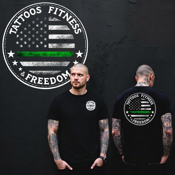 Man wearing a black t-shirt featuring a green line American flag design symbolizing the thin green line.